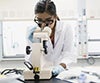 Ricercatore al lavoro con microscopio